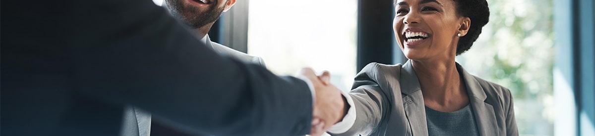 Un empresario da la mano a una empresaria